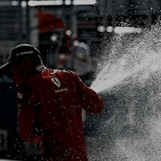 a man in red jacket spraying water on his face