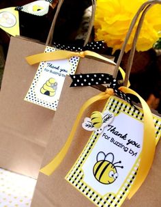 two brown paper bags with yellow and black ribbon tied to them, one has a thank you for bees on it