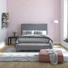 a bedroom with pink walls and grey bedding, white rugs and wooden flooring