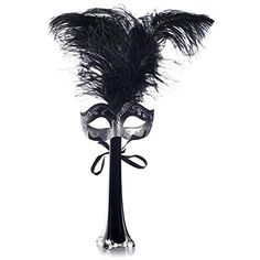 a masquerade mask with black feathers on a stick in front of a white background