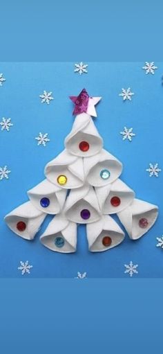 an origami christmas tree made out of white paper with colorful buttons on it