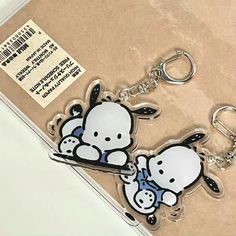 two keychains with cartoon characters on them sitting next to each other in a box