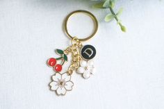 a close up of a keychain with flowers and cherries attached to it