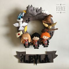 a group of toy figurines sitting on top of a wooden sign next to a wall