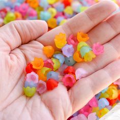 a person's hand is full of small plastic flowers