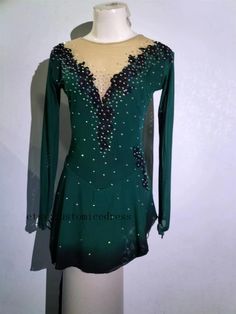 a woman's green ballroom dress with beading and sequins on it