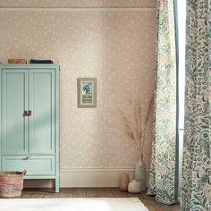 a blue cabinet sitting in the corner of a room next to a window with curtains