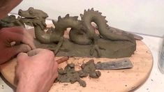 a man is making clay sculptures on a table