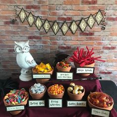 a table topped with lots of different types of candies next to a brick wall