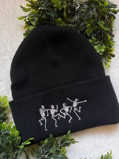 a black beanie with three skeletons on it