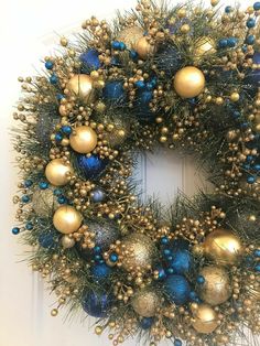 a christmas wreath with blue and gold ornaments