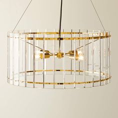 a chandelier with three lights hanging from it's sides and gold trimmings