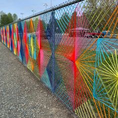 the fence is painted with many different colors and shapes, including starbursts