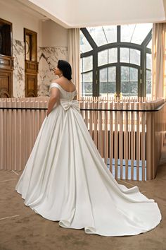 a woman in a wedding dress looking out the window