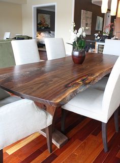 a wooden table sitting on top of a hard wood floor next to a white chair