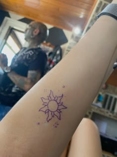 a woman's arm with a tattoo on it and a man in the background