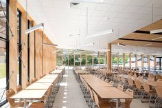 an empty classroom with wooden tables and chairs