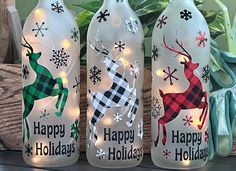 three bottles decorated with holiday lights and reindeers