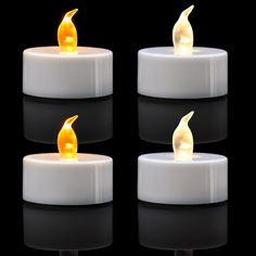 three lit candles sitting side by side on a black surface with reflections in the dark