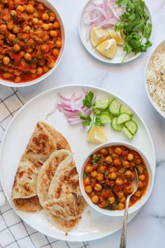 three plates filled with food on top of a white tablecloth next to bowls of vegetables and rice