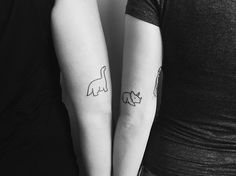 two people with matching tattoos on their arms, one has a cat and the other has a dog