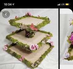 three tiered trays with pink flowers and grass on the bottom one is made out of wood