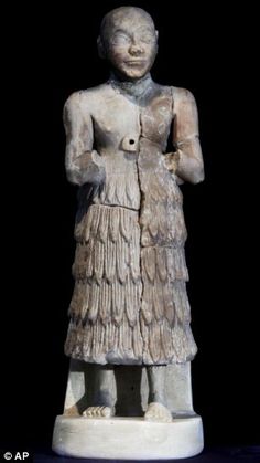 an ancient statue is standing on a black surface with its hands in her pockets and wearing a dress