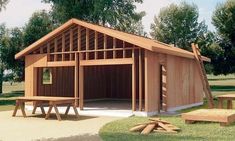 a wooden structure with picnic tables in front of it