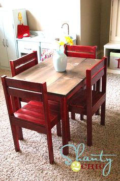 a small wooden table and chairs in a room with carpeted flooring on the floor