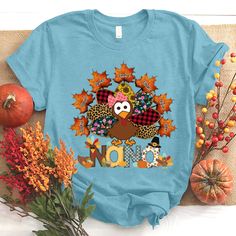 a blue shirt with an image of a turkey and the word nom on it