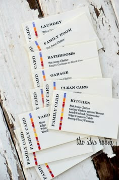 five business cards sitting on top of an old wooden table with the names of different rooms