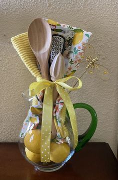 a glass vase filled with lemons and wooden spoons