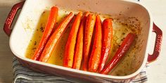 carrots in a casserole dish with mustard and seasoning on the side