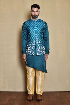 Blue sleeveless mandarin collar bundi in silk base with mystic gladiolus bloom embroidered details. Paired with a full sleeves cross cut hem plain kurta and gold pant. - Aza Fashions Fitted Blue Nehru Jacket For Diwali, Blue Sleeveless Kurta For Festive Occasions, Festive Sleeveless Blue Kurta, Festive Blue Sleeveless Kurta, Designer Blue Nehru Jacket With Pallu, Fitted Blue Nehru Jacket For Designer Wear, Fitted Blue Nehru Jacket For Designer Events, Fitted Nehru Jacket With Stand Collar For Transitional Season, Traditional Blue Bandhgala With Stand Collar