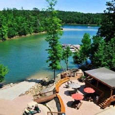 an aerial view of the lake and dock area with picnic tables, umbrellas and lounge chairs