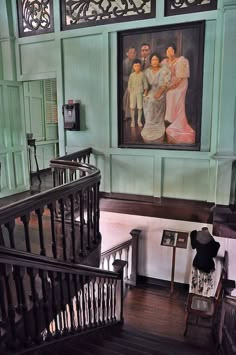 an ornate staircase with paintings on the wall and wooden handrails in front of it