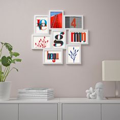 a white table topped with lots of pictures and a vase filled with green plant next to it