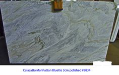 a marble counter top that has a wooden handle on the bottom and an ad for calacatta manhattan blue 3cm polished