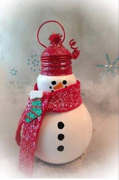 a snowman ornament with a red hat and scarf