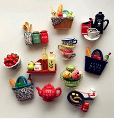 a collection of miniature food items on a white surface, including teapots and cups