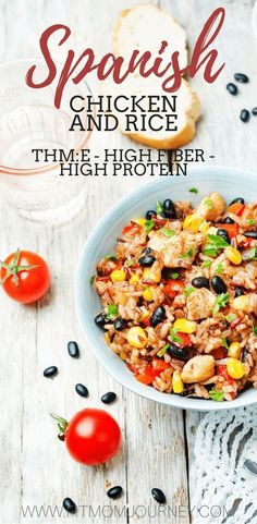 a white bowl filled with chicken and rice next to tomatoes, black olives and bread