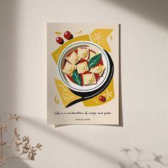 a plate of ravioli on a yellow and white background next to a vase with flowers