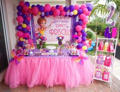 a pink and purple birthday party with balloons