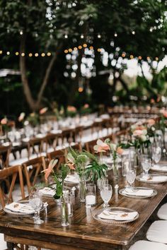 a long wooden table topped with lots of plates and glasses