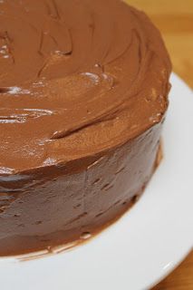 a chocolate frosted cake on a white plate