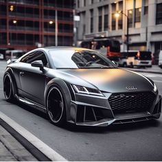 an audi car is parked on the side of the road in front of some buildings