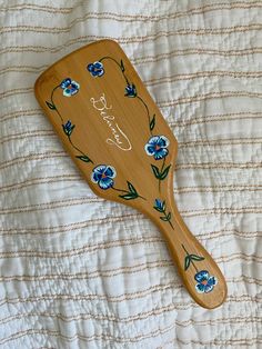 Handpainted wooden hairbrush, painted hairbrush inspo, blue florals, handpainted violet flowers, bridesmaid gift ideas, birthday gift ideas, christmas list, christmas wish list, handmade christmas gift ideas, painting inspo, gift inspo, handpainted blue flowers Painting Gifts For Mom, Painted Hairbrush Diy, Hair Brush Painting, Painting Hairbrushes, Painted Hair Brush, Hairbrush Paint Ideas, Wooden Coaster Painting Ideas, Thoughtful Gifts For Sister, Hairbrush Aesthetic