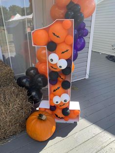 a number one made out of balloons and pumpkins