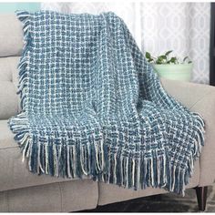 a blue and white plaid blanket sitting on top of a couch