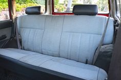 the interior of a car with blue and white seat covers on it's back